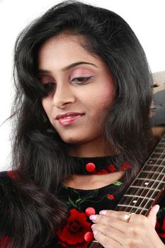 A portrait of a beautiful young Indian guitarist lost in her dreams, on white background.
