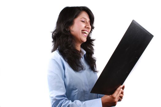 A metaphorical portrait of an Indian businesswoman sarcastically laughing looking at a business offer document, on white studio background.