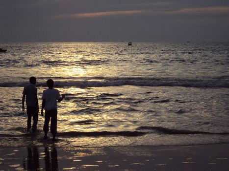 Friends along the Calangute Beach in Goa, India at Sunset