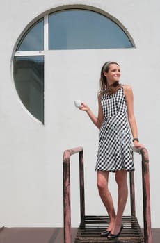 beautiful girl in plaid dress with coffee cup on open air