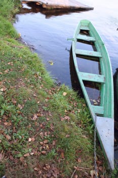 Vintage, old green boat on lake beach