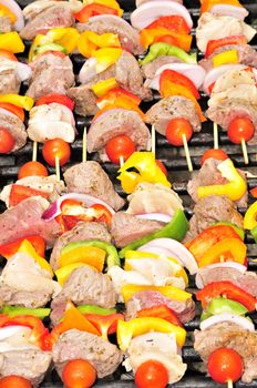 An assortment of shish kabobs grilling on an open.