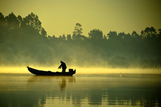 The boatman fishing on a lake.