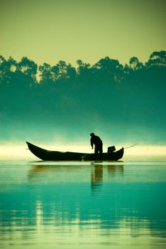 The boatman fishing on a lake.