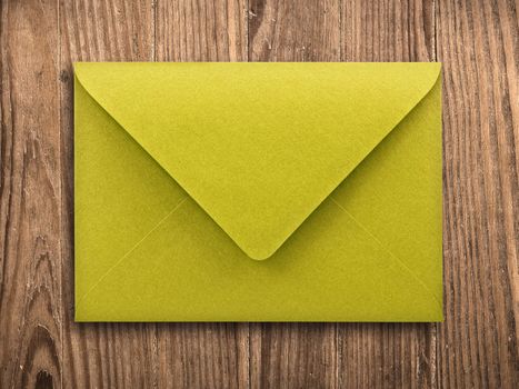 yellow envelope on old wooden table, with clipping path.