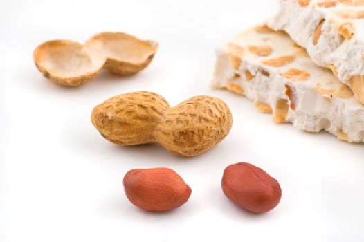 Nougat and peanuts on white background, close up shot.