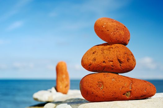 Three red stones on a beach in the morning in the summer