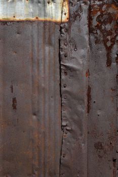 Battered, damaged, grunge rusty sheet metal background.