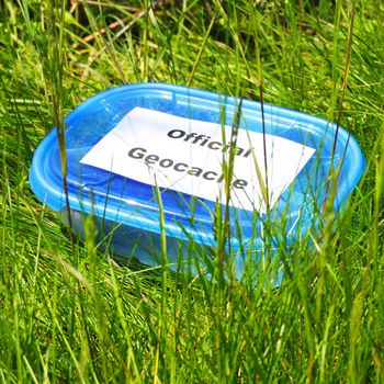 geocaching concept with blue geocache box showing outdoor sports concept