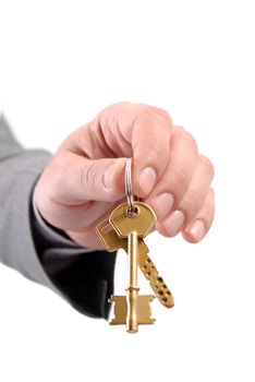 Close-up picture of a male real estate executive's hand holding two keys.