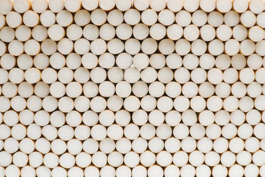 Symmetrical pile of cigarettes shot from the filter side.