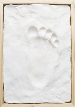 Small child memory footprint on clay in wooden frame