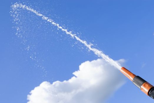 Stream of water flowing in the sky from the hose