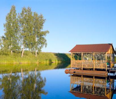 Small pond in the evening and old arbour on pontoons