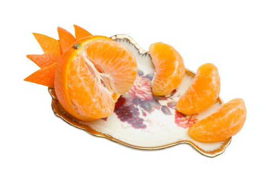 Orange tangerine devided into segments and decorated with peel on beauty fruit dish. Isolated on white background