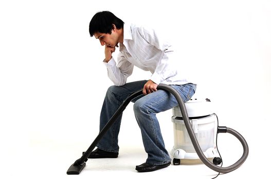 man sitting and thinking on a vacuum cleaner looking tired and depressed