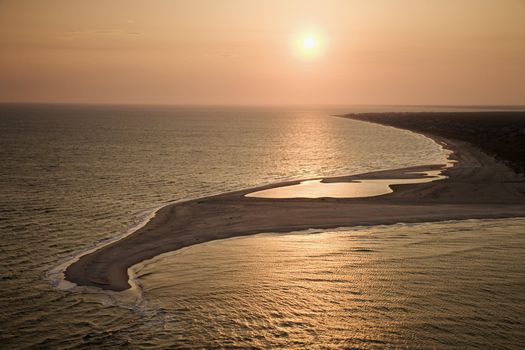 Aerial view of sun over Atlantic ocean and shoreline of Bald Head Island, North Carolina.