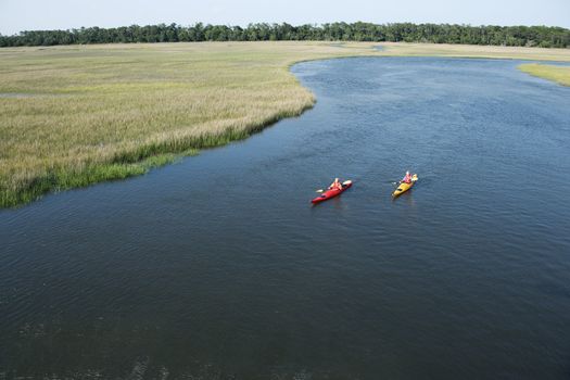 Aerial of two teenage boys kayaking through marshland on Bald Head Island, North Carolina.