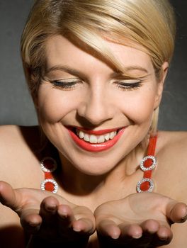 pretty girl in red dress holding imaginary object on her palms