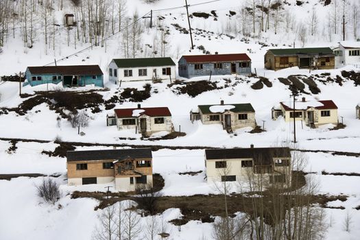 Rural abandoned houses on snowy mountainside.