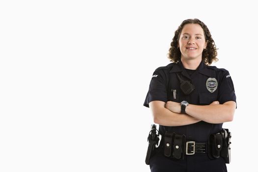Portrait of mid adult Caucasian policewoman standing with arms crossed looking at viewer smiling.