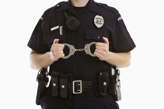 Close up of mid adult Caucasian policewoman holding locked handcuffs.