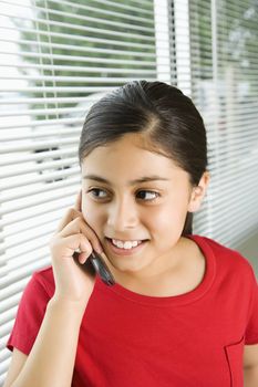 Hispanic preteen girl talking on cell phone.