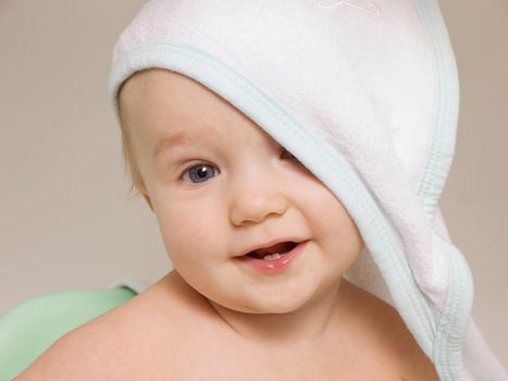 Smiling baby with towel on his head after bath