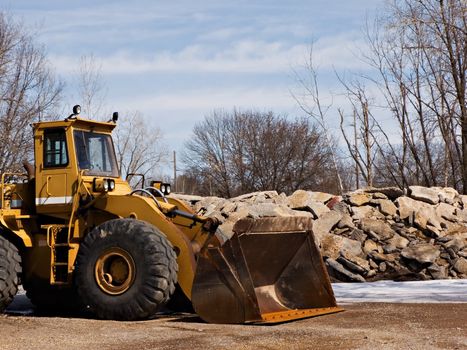 Front loader near a pile of large stones