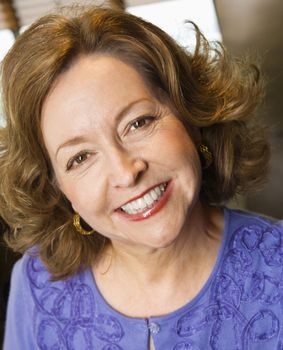 Head and shoulder portrait of smiling middle aged Caucasian woman.