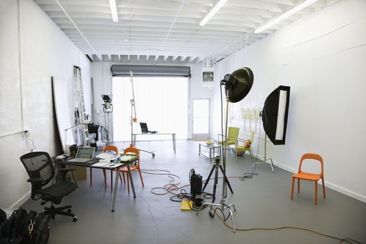 Interior of photography studio with lights and various equipment and props.