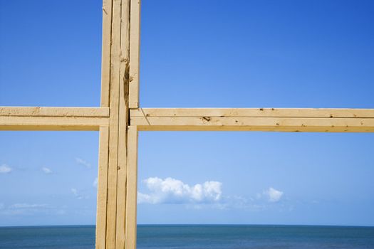 Ocean and sky behind new construction framed window.