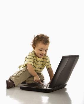 Happy African American toddler boy on laptop computer.