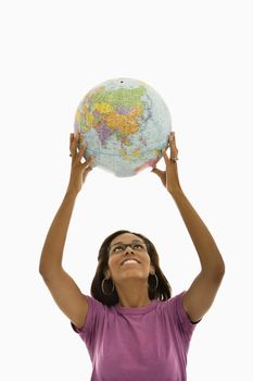 African American mid adult woman holding globe over head and looking up.