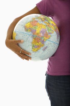 Arm and hips of African American woman holding globe.