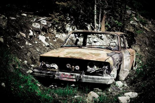 Creative photo of old rusty car in forest after accident