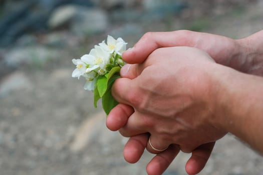 bouquet of white flowers in man hands 

