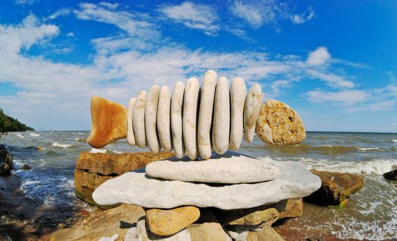 Stone fish on seacoast at midday in the summer