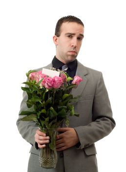 A young man holding a vase of roses with a sad expression on his face, isolated against a white background