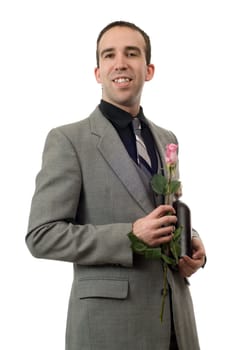 Young man wearing a suit and tie, holding a single rose and a bottle of champagne