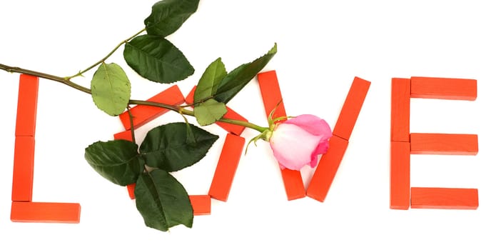 The word love spelled with red blocks and a pink rose