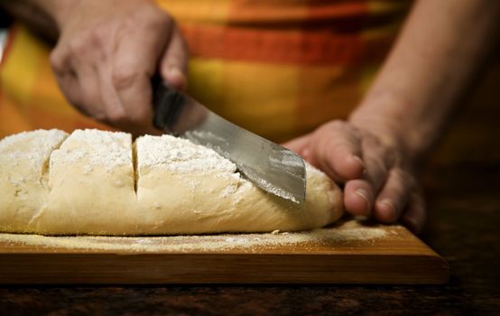 Adding cut to unbaked bread dough with serrated knife