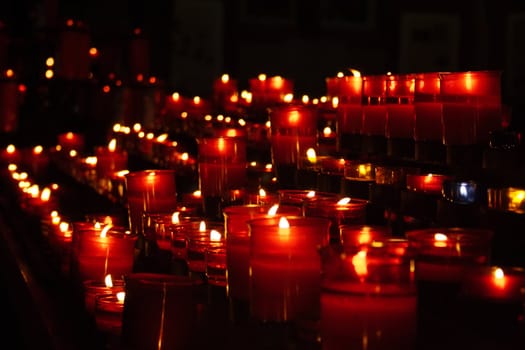Red candles in church forming converging lines