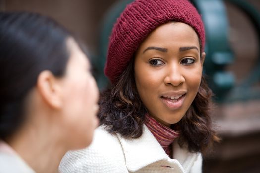 Two business women having a casual meeting or discussion in the city. Shallow depth of field.