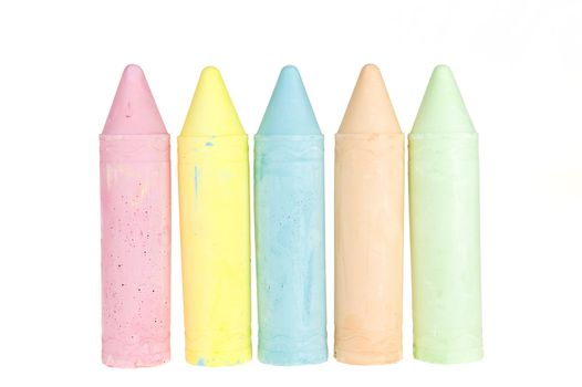 five colorful chalks on a white background