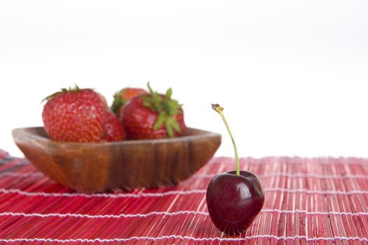 a cherrry at the front and strawberries at the back