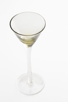 Small yellow cocktail glass against a white background