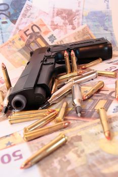 gun bullets and money showing a dangerous side to life