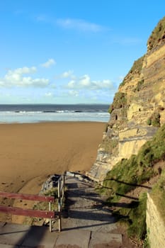 a path to the waves crashing in on ballybunion beach ireland