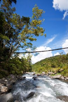 A tropical mountain stream with hanging bridge